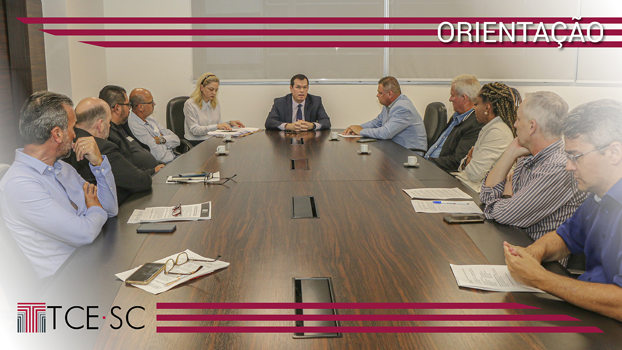 Foto com os participantes da reunião, sentados em volta de uma mesa. O presidente do TCE/SC está na cabeceira da mesa. À sua direita, está a chefe do Gabinete da Presidência e quatro homens. À sua esquerda, o prefeito, uma mulher e mais três homens. Sobre a foto, nas partes superior e inferior, listras horizontais na cor bordô, a palavra Orientação e a logomarca do TCE/SC. 