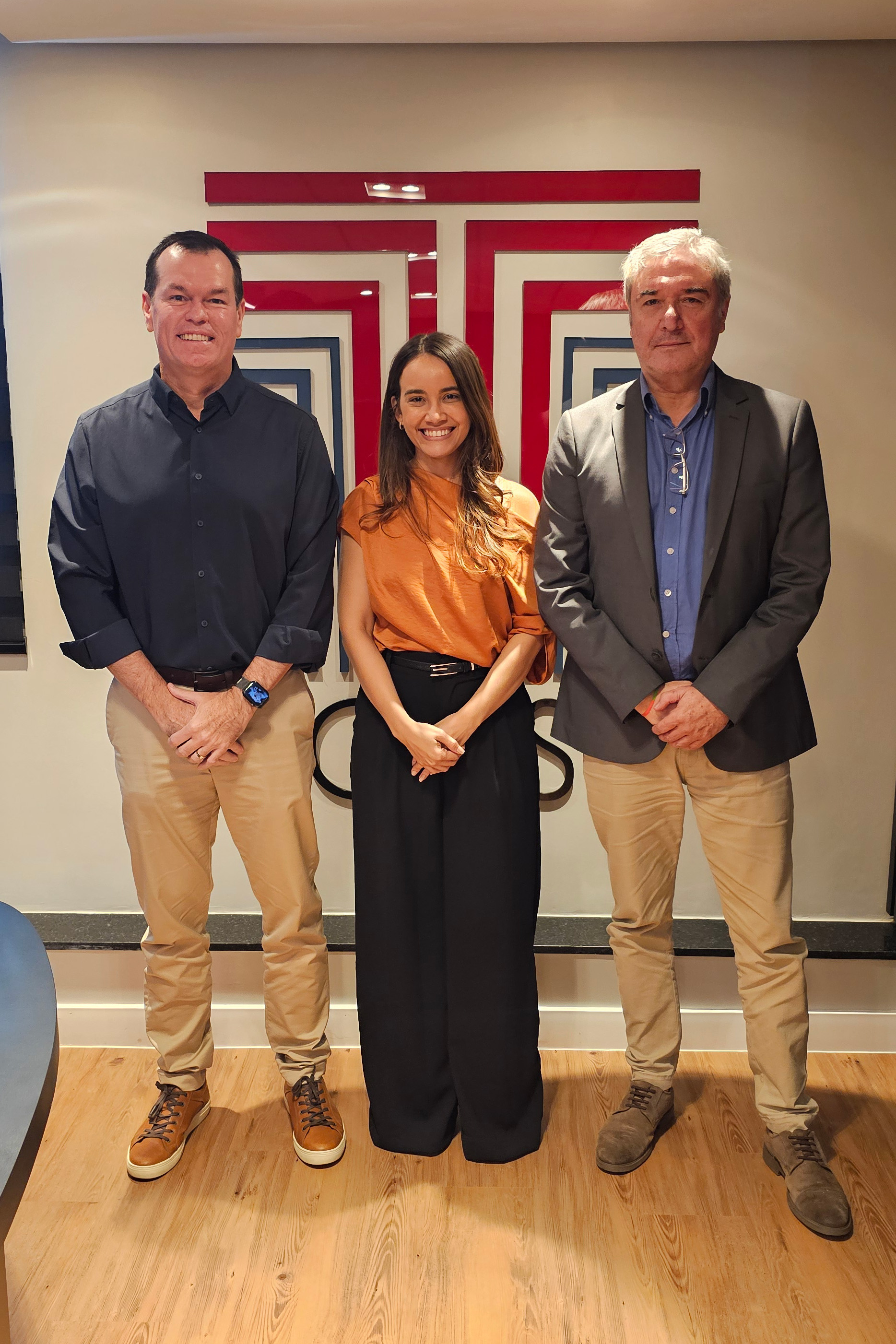 Foto vertical. Ao centro, a servidora Julia Maria Leal dos Santos.À esquerda, o conselheiro Adircelio de Moraes Ferreira JR , e à direita, o orientador professor doutor Luiz Henrique Cademartori.