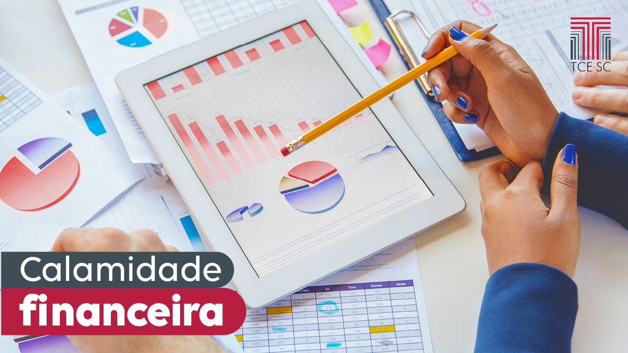 Imagem mostra gráficos coloridos ao centro, em uma tela de tablet que está sobre uma mesa. À direita, aparecem as mãos de uma mulher que segura um lápis alaranjado que está apontado para os gráficos. À direita há a expressão Calamidade Financeira.