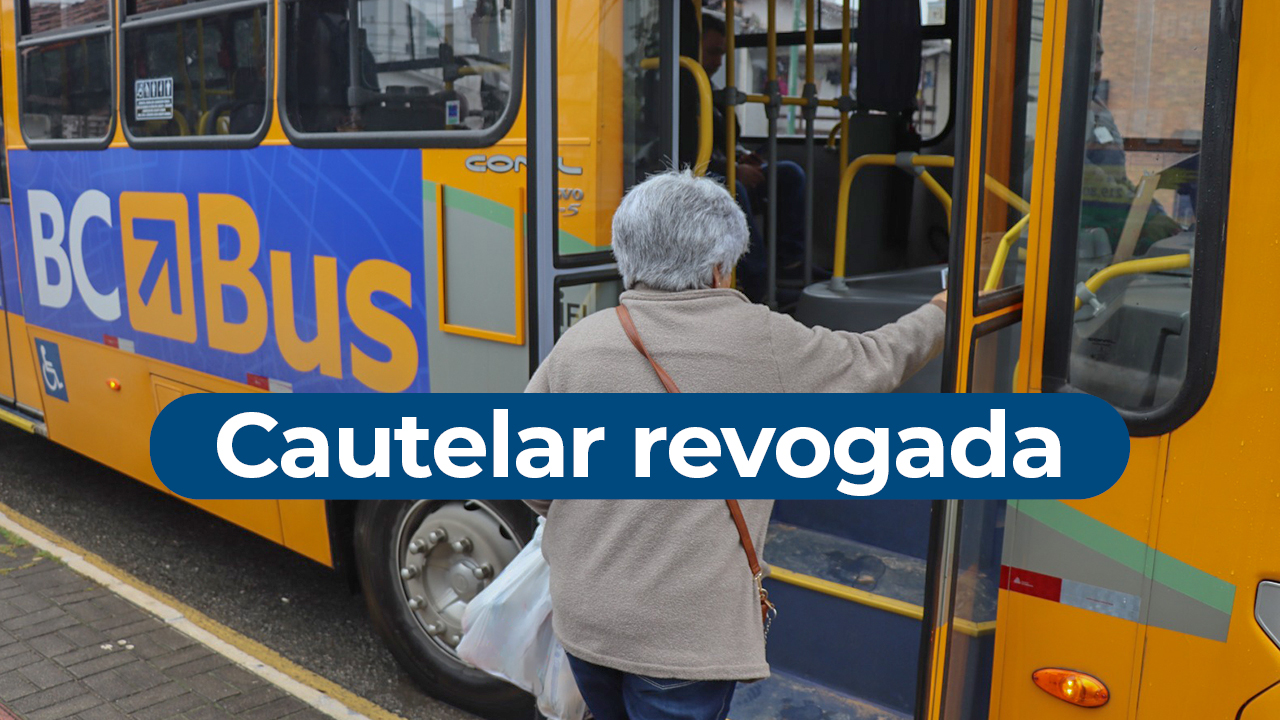 Imagem mostra uma idosa subindo em um ônibus amarelo pela porta da frente. Na lateral do veículo está escrito “BCBus”. Ao centro, sobre uma tarja branca, aparece escrito “cautelar revogada”