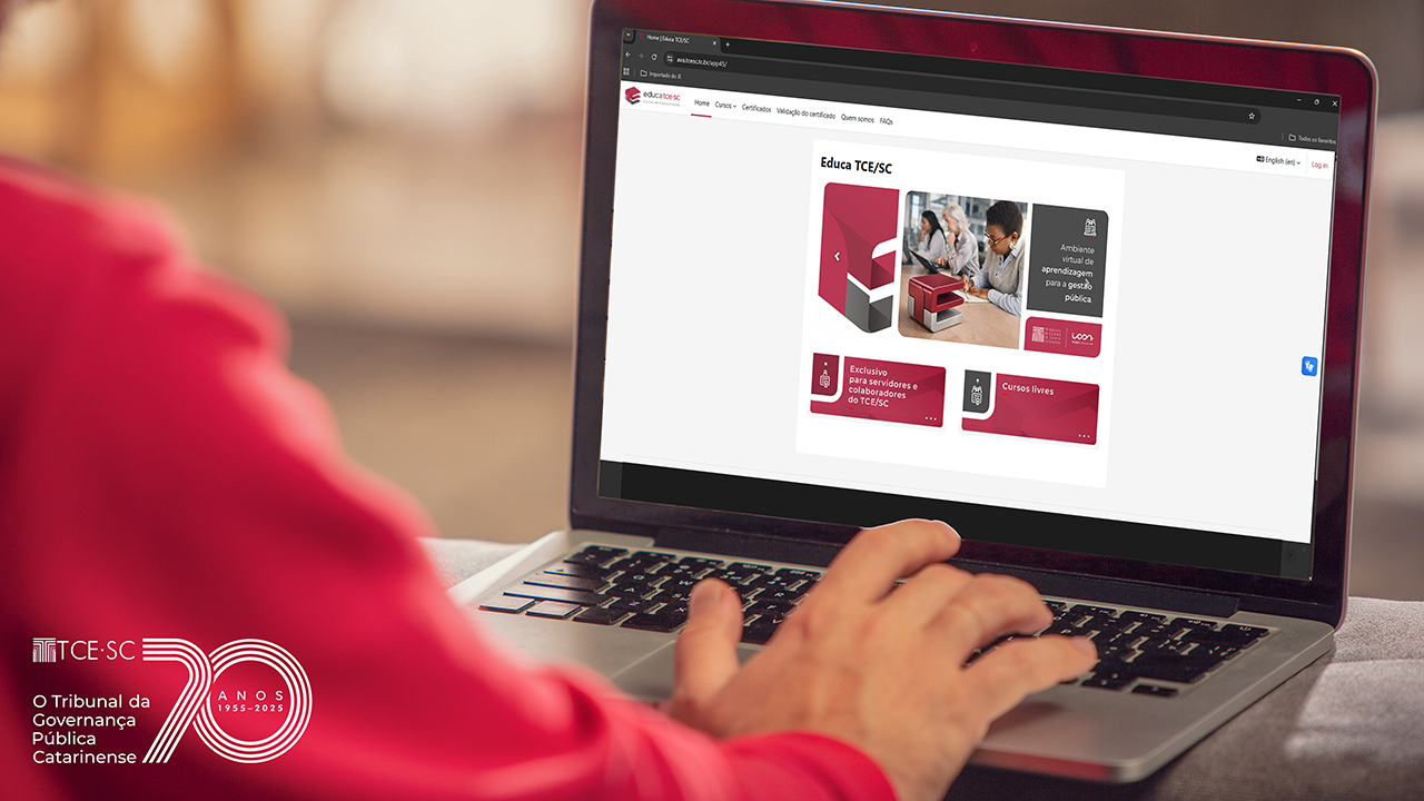 Banner horizontal com foto que mostra uma pessoa utilizando um notebook, com as mãos sobre o teclado, acessando uma plataforma digital exibida na tela. O site apresenta a interface do “Educa TCE/SC”, com cards de cursos e conteúdos relacionados à capacitação na área pública. No canto inferior esquerdo, logo do TCE/SC.
