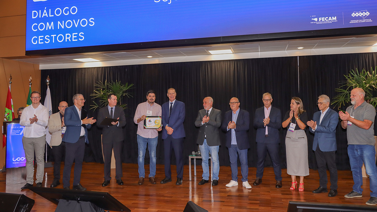 Banner horizontal com foto das autoridades no palco do auditório. Entre os presentes, os conselheiros do Tribunal Herneus João De Nadal — presidente — Adircélio de Moraes Ferreira Júnior — corregedor-geral —, Wilson Rogério Wan-Dall — supervisor da Ouvidoria — e Luiz Eduardo Cherem, o conselheiro substituto Gerson dos Santos Sicca, o diretor-geral de Controle Externo, Sidney Antonio Tavares Junior, o diretor do Instituto de Contas, Moises Hoegenn, e representantes das prefeituras agraciadas com o diploma.