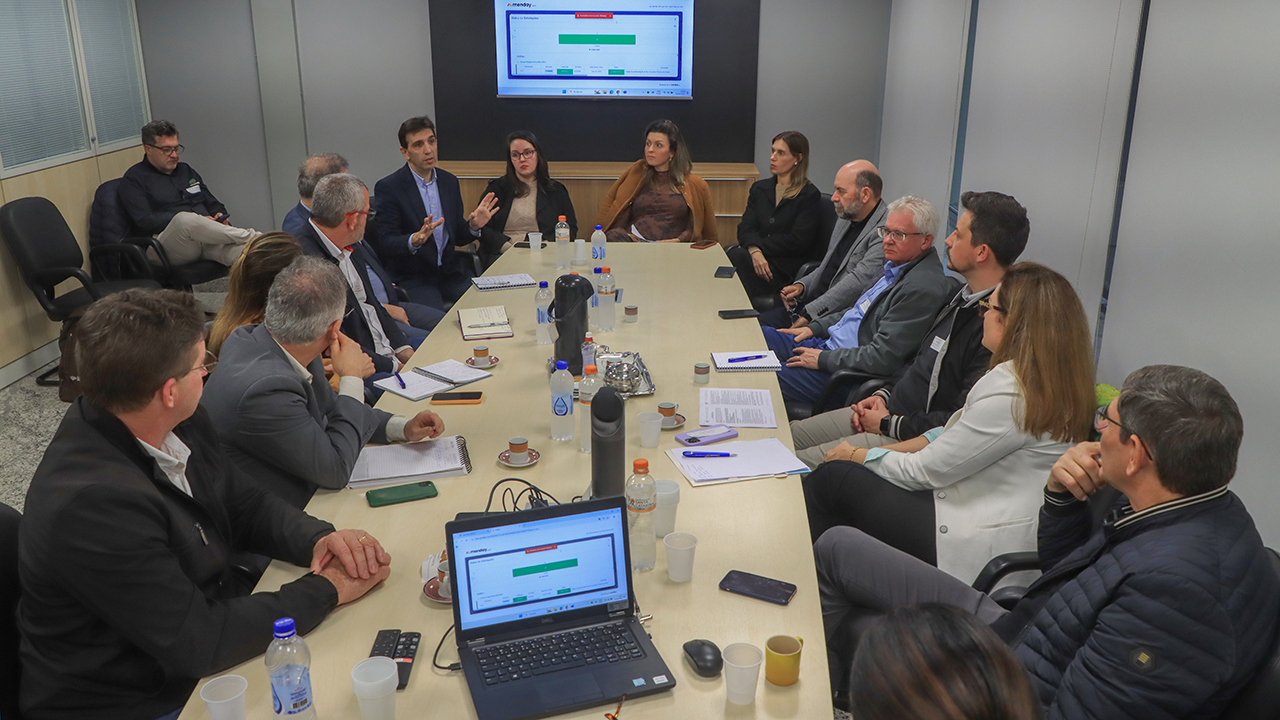 Banner horizontal com foto de várias pessoas sentadas ao redor de uma mesa de reuniões. Entre os presentes, representantes das associações de municípios e diretores do TCE/SC.