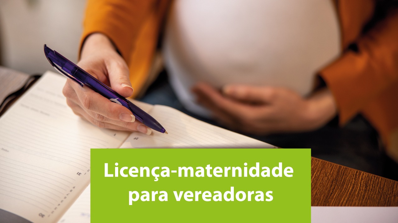 Banner horizontal com foto de mulher grávida sentada à mesa, segurando uma caneta e escrevendo em um caderno ou agenda, enquanto apoia a outra mão sobre a barriga. Na parte inferior da imagem, há um destaque em fundo verde com o texto “Licença-maternidade para vereadoras”. 