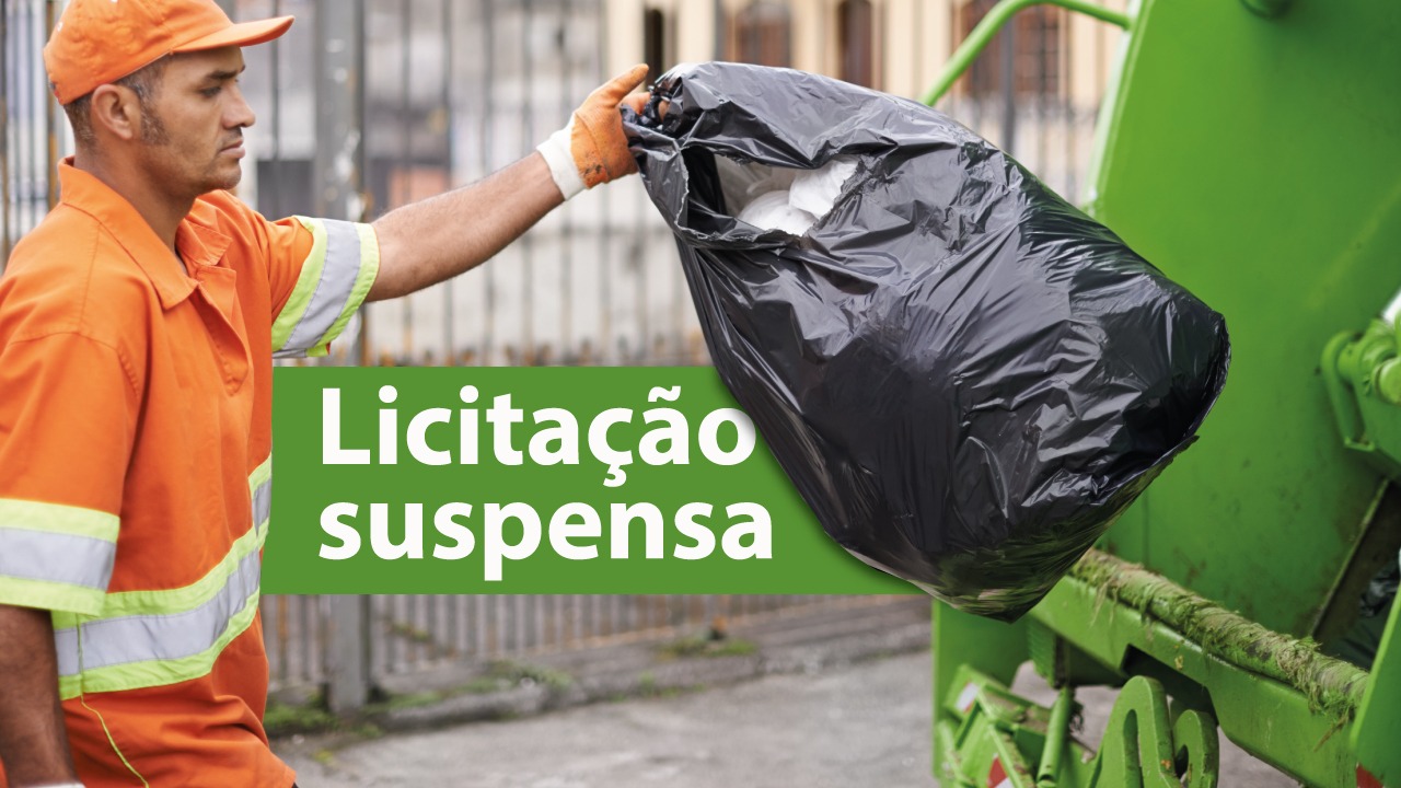 Banner horizontal com imagem de um trabalhador da limpeza urbana, vestido com uniforme laranja e luvas, descartando um saco de lixo preto em um caminhão coletor verde. À esquerda, em destaque sobre uma faixa verde, aparece o texto “Licitação suspensa”. 