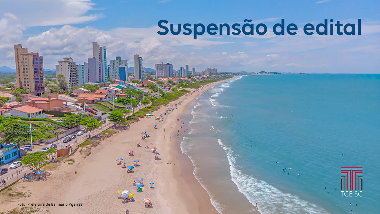 Foto aérea de uma praia da cidade de Balneário Piçarras. À esquerda da foto aparece parte da cidade com prédios, casas, ruas e árvores; ao centro a faixa de areia, com vários guarda-sóis e banhistas; e à direita, o mar. Sobre a foto, no canto superior direito há o título “Suspensão de edital”, e no canto inferior direito, a logo do TCE/SC. No canto inferior esquerdo, em fonte bem pequena, há a identificação do crédito da foto, com o texto “Foto: Prefeitura de Balneário Piçarras”.