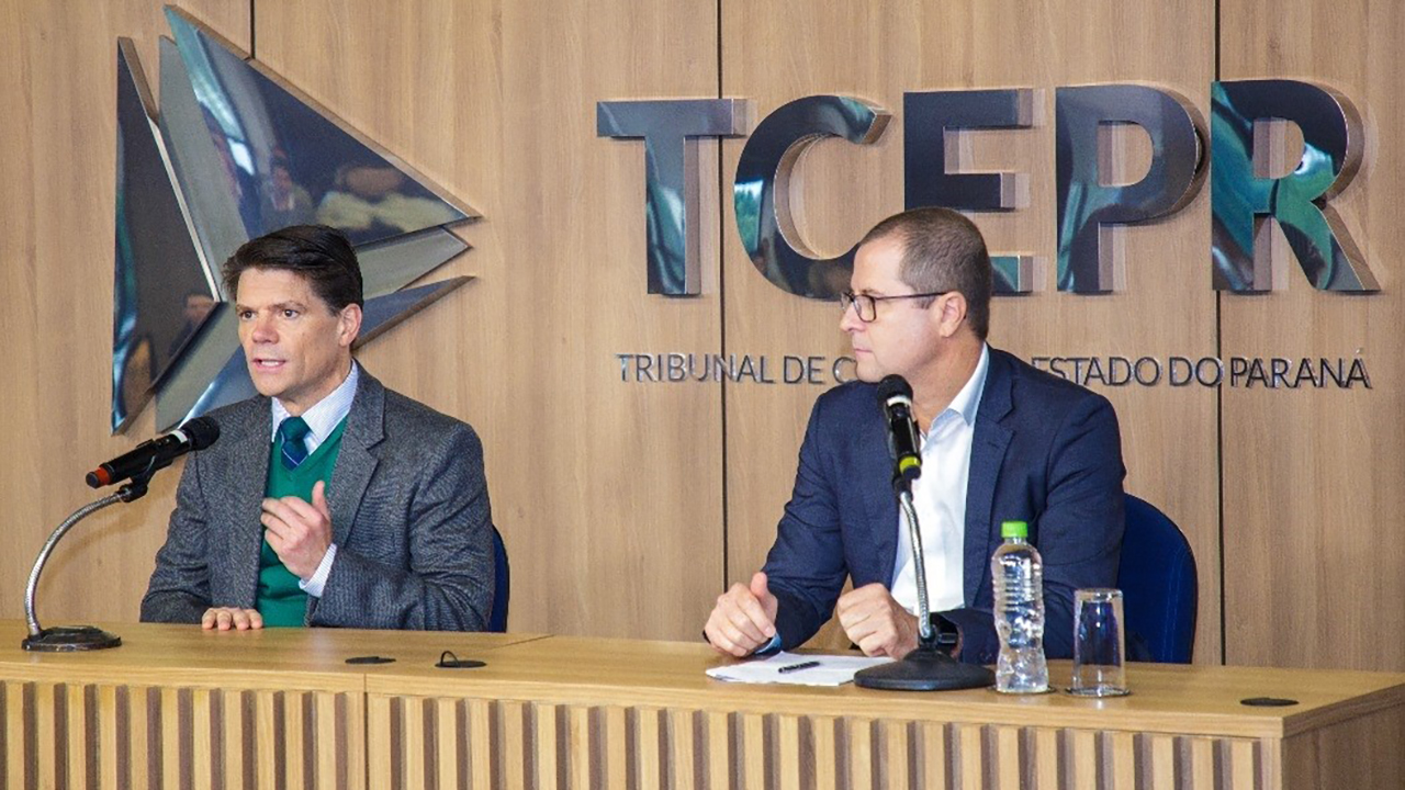 Banner horizontal com foto do diretor Nilsom Zanatto, do TCE/SC, ao lado do presidente do TCE/PR, conselheiro Ivens Linhares. Eles estão sentados diante de uma bancada, falando ao microfone. Ambos vestem paletó. Ao fundo, na parede, logo do Tribunal de Contas do Paraná.