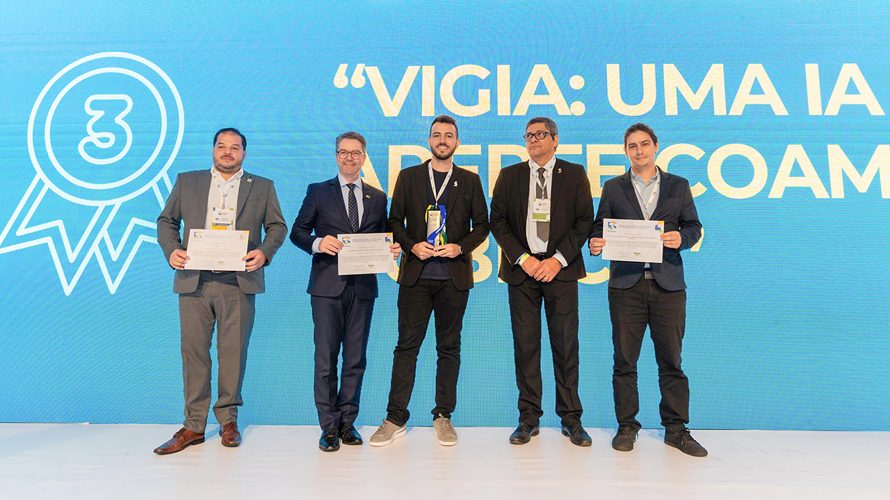 Foto dos premiados do Prêmio Excelência em Governo Digital. Há cinco homens em pé, um ao lado do outro. Três seguram os certificados. Entre eles, o auditor fiscal de controle externo do TCE/SC Thiago Sodré. 