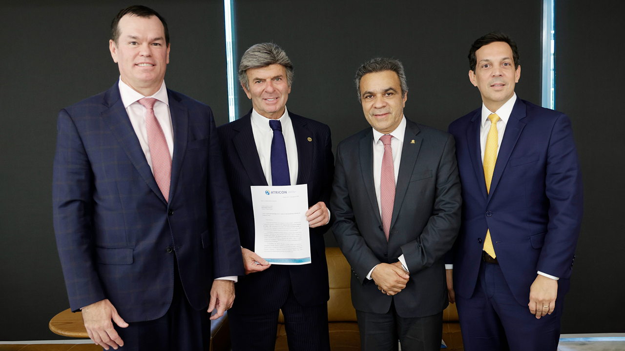 Foto de quatro homens, um ao lado do outro, em pé. São eles: conselheiro Adircélio de Moraes Ferreira Júnior, conselheiro Edilson Silva, ministro Mauro Campbell e ministro Luiz Fux. Todos vestem terno e gravata e sorriem. O ministro Campbell segura e mostra uma folha de papel para a foto.