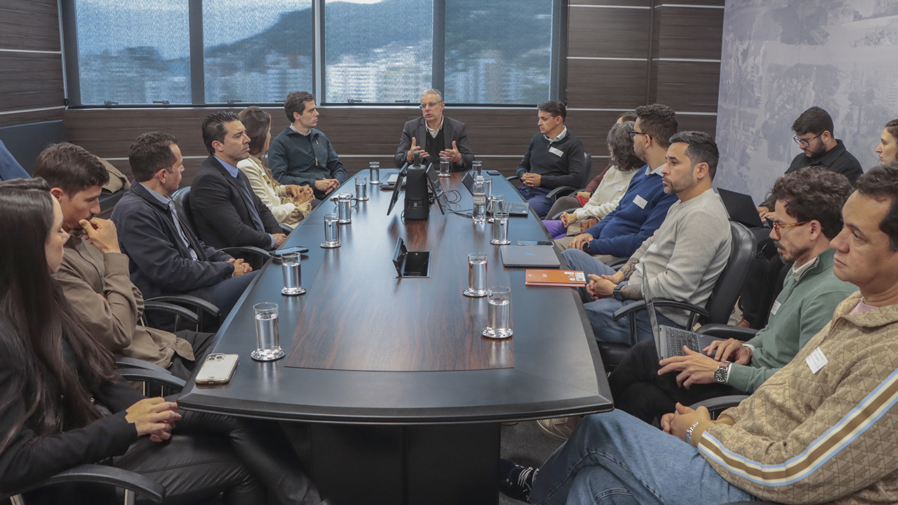 Banner horizontal com foto de vários participantes da reunião sentados em torno de uma mesa, enquanto conversam. Entre os presentes, o conselheiro substituto Gerson Sicca, representantes do Todos Pela Educação e da Secretaria Municipal de Florianópolis.  