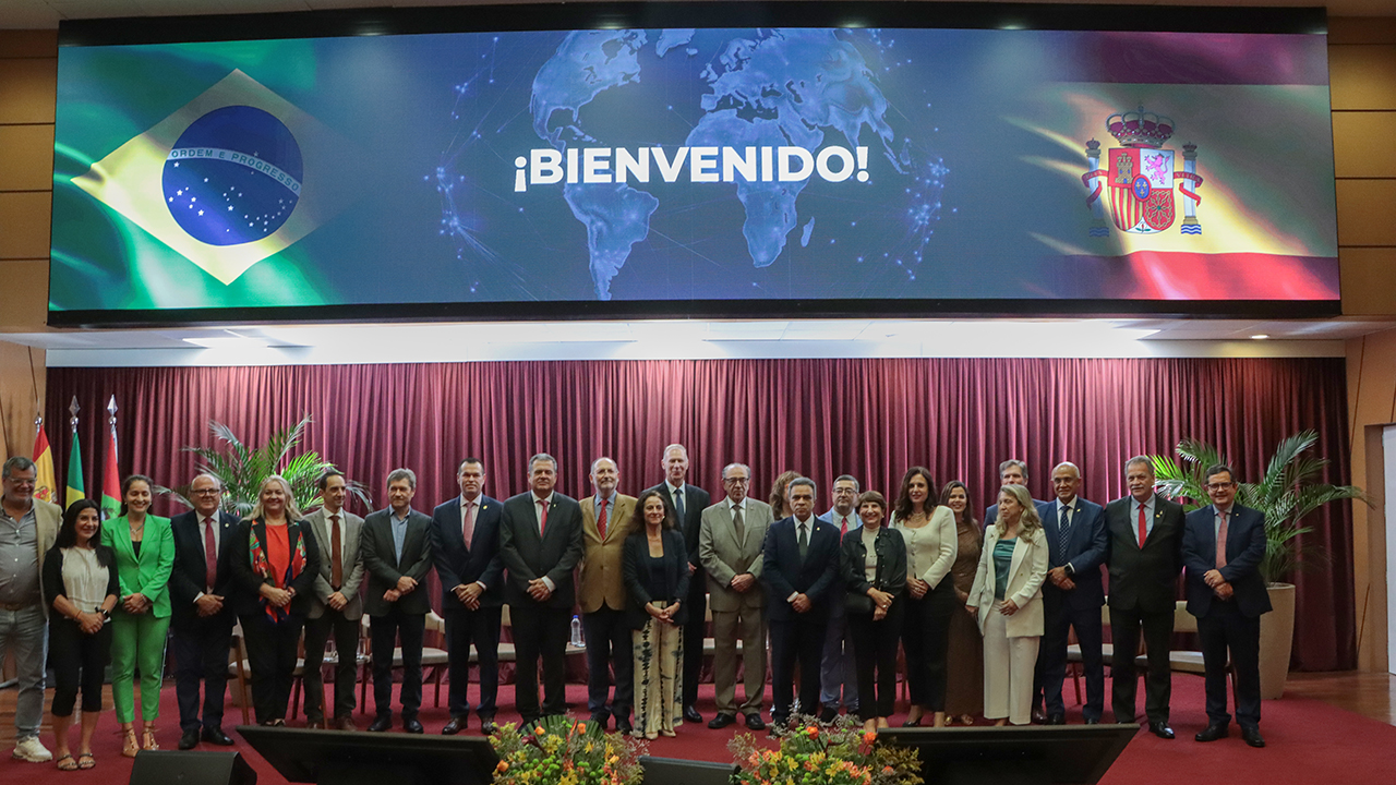 Foto horizontal com várias autoridades no palco do auditório bordô do TCE/SC, em pé, lado a lado, posando para a foto. Entre os presentes, o presidente do TCE/SC, conselheiro Herneus De Nadal, o presidente da Atricon, Edilson Silva, e o presidente do IRB, Edilberto Lima, além da comitiva da Espanha.
