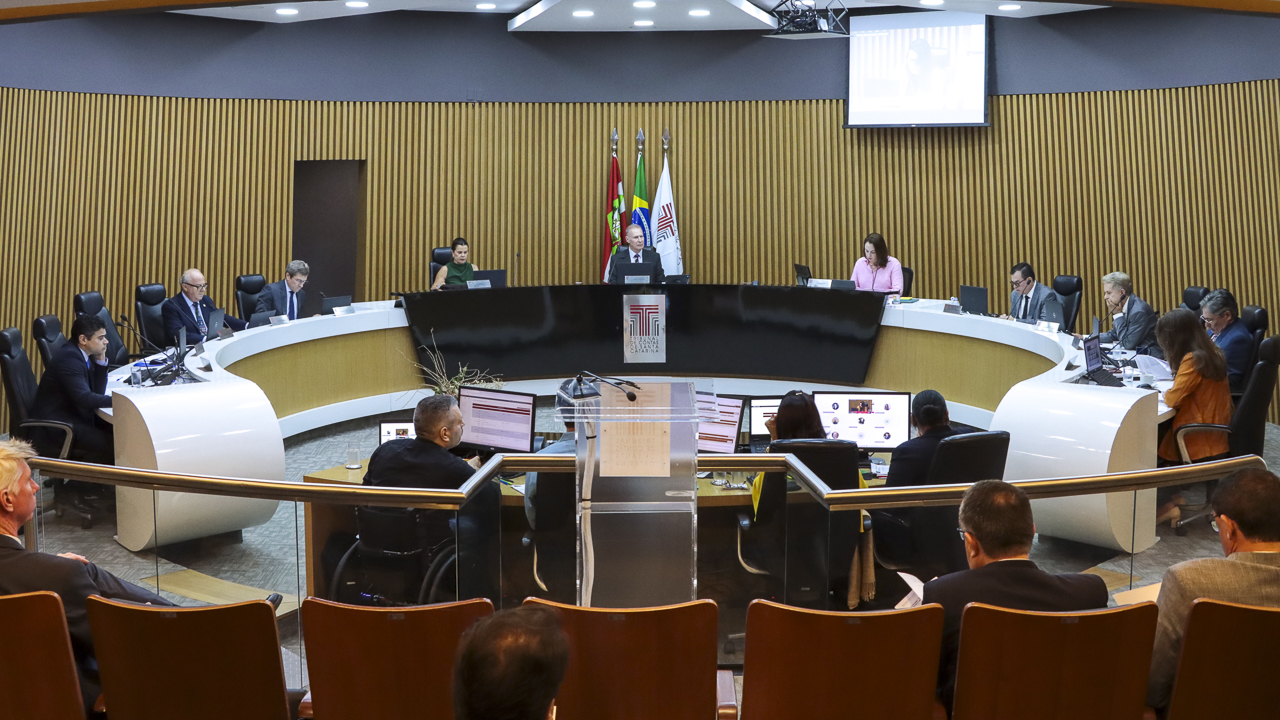 Banner horizontal com imagem das autoridades na bancada circular do Plenário do TCE/SC. Ao centro, o presidente, conselheiro Herneus De Nadal. Nas laterais, os demais conselheiros. 