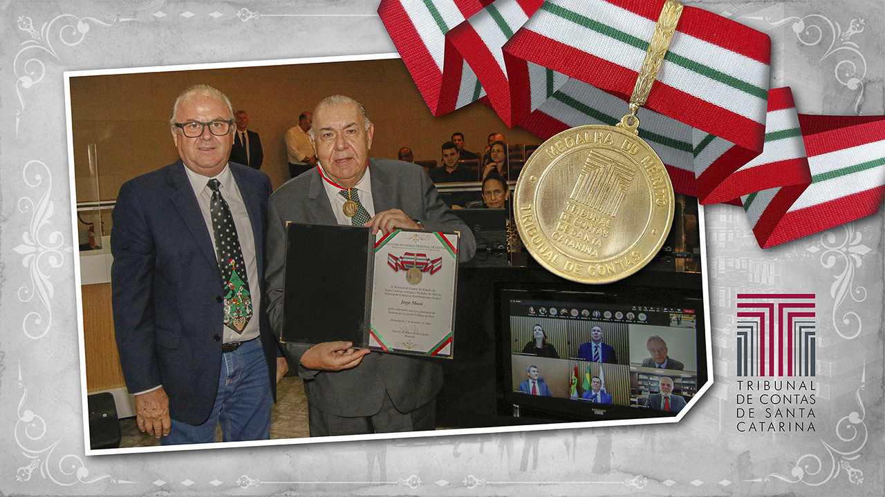 Banner com fundo em tons de cinza. Sobre o fundo, foto do ministro Jorge Mussi com a Medalha do Mérito Tribunal de Contas e com o diploma, em pé, junto com o conselheiro do TCE/SC Wilson Wan-Dall. No canto superior direito, imagem da medalha. No canto inferior direito, imagem da logomarca do TCE/SC.