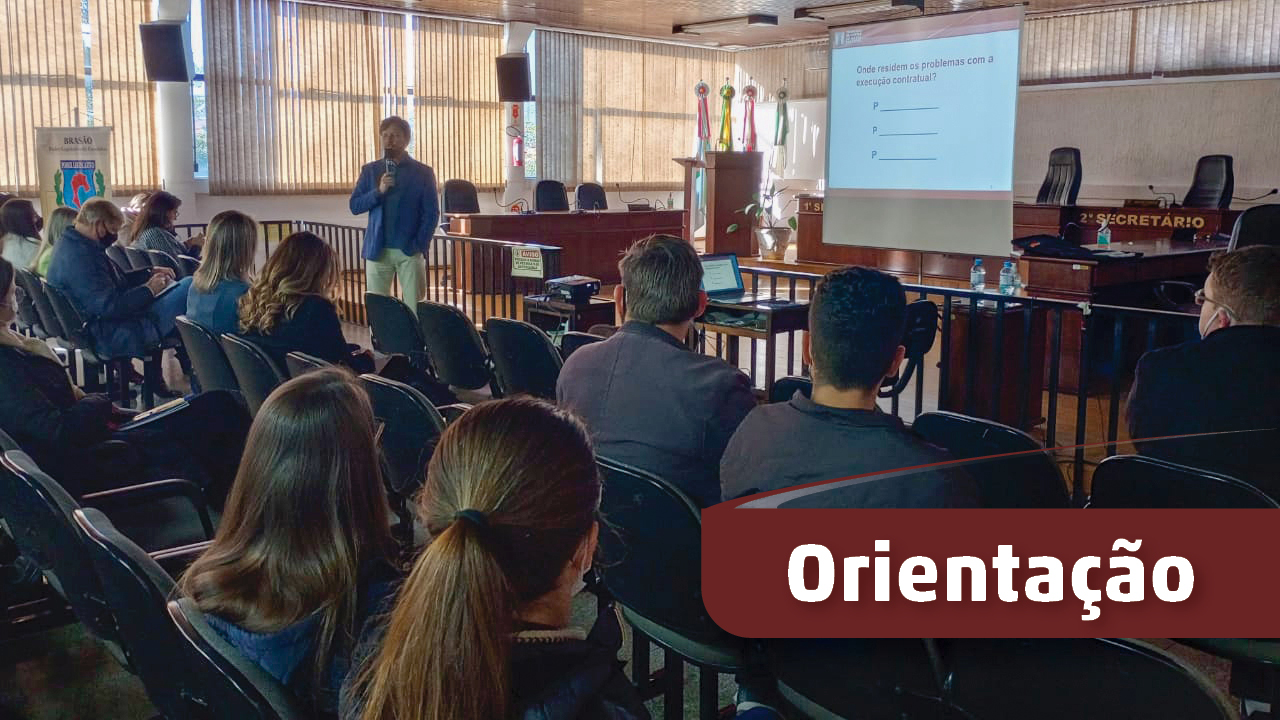 Banner com fotografia da apresentação. Sala com palestrante falando para várias pessoas. A palavra Orientação, em branco com fundo vermelho, no canto inferior direito.