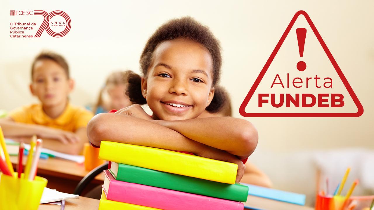 Banner de um menino debruçado sobre uma pilha de livros, sorrindo. Ele está em uma sala de aula. Sobre a foto, à direita, o texto “Alerta Fundeb”, dentro de um ícone de atenção. No canto superior esquerdo, selo comemorativo aos 70 anos do TCE/SC.