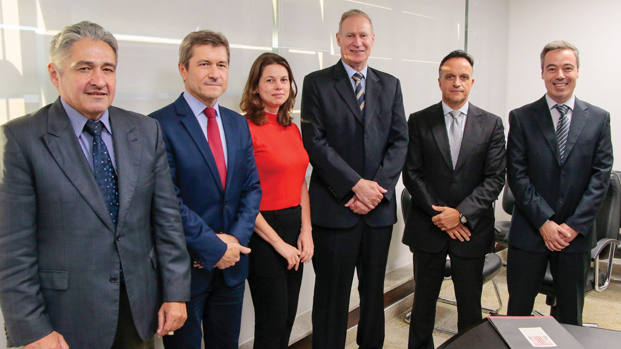 Foto horizontal com seis pessoas em pé. Da esquerda para a direita: conselheiro Aderson Flores, conselheiro José Nei Ascari, conselheira substituta Sabrina Nunes Iocken, conselheiro Herneus De Nadal, subprocurador-geral para assuntos institucionais do MPSC, Paulo Locatelli, e controlador-geral do Estado, Márcio Cassol Carvalho 