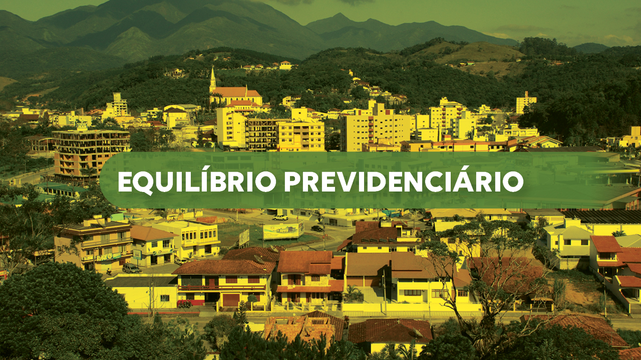 Banner horizontal com foto, com filtro amarelado, de uma vista panorâmica de uma cidade com casas e prédios, cercada por morros e montanhas ao fundo. No centro da imagem há uma faixa verde translúcida com o texto “Equilíbrio previdenciário”. 
