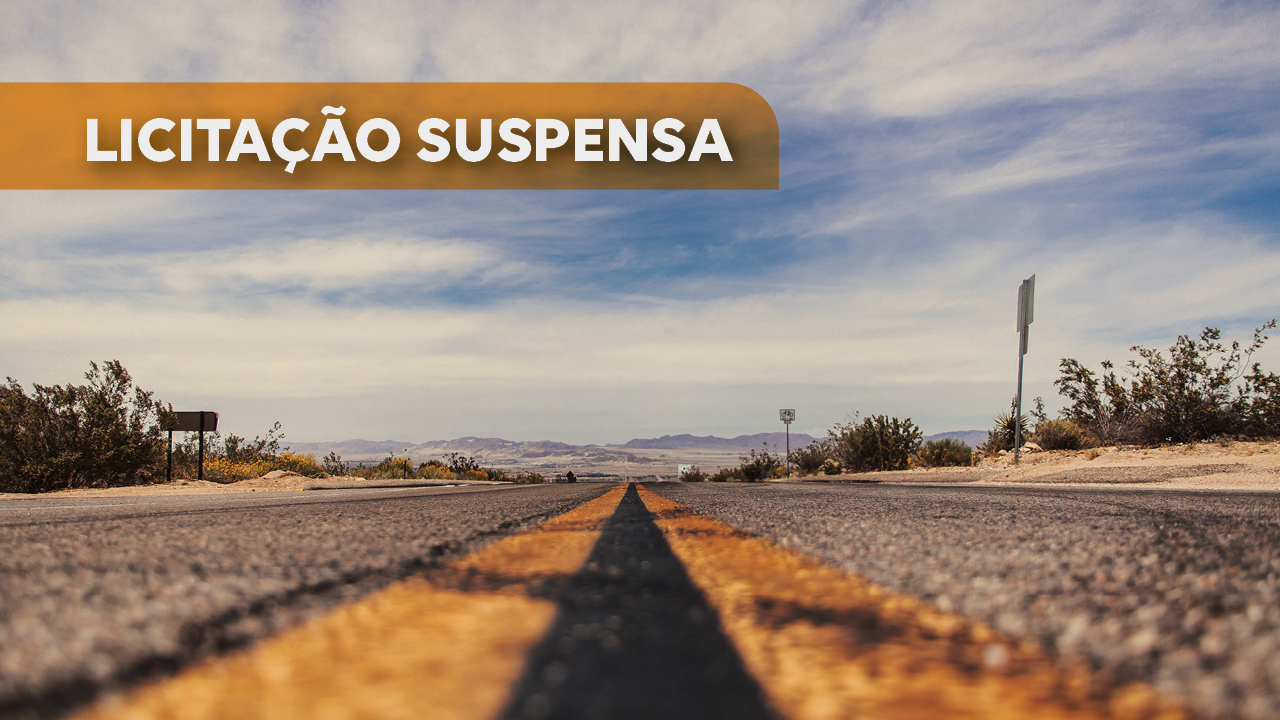 Banner horizontal com foto de uma via. A foto mostra as linhas amarelas que separam as faixas. Sobre a imagem, no canto superior esquerdo, em tarja amarela, o texto “Licitação suspensa”. 