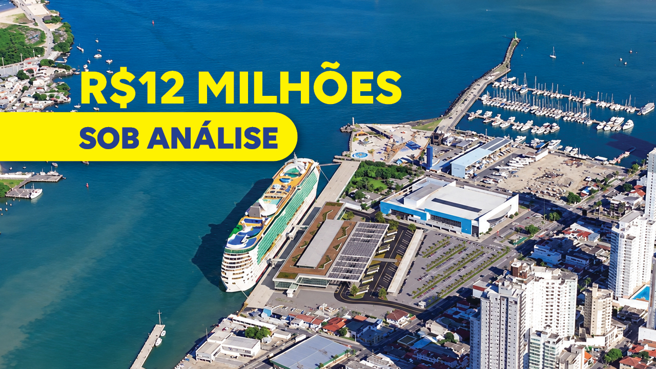 Banner horizontal com imagem aérea com foto de uma área portuária e urbana à beira-mar. Em destaque, um grande navio de cruzeiro está atracado em um terminal cercado por edificações, estacionamentos e vias de circulação. À direita, há uma marina com dezenas de embarcações ancoradas em píeres que avançam sobre o mar azul. Sobre a imagem, em amarelo, o texto "12 milhões de reais sob análise". 