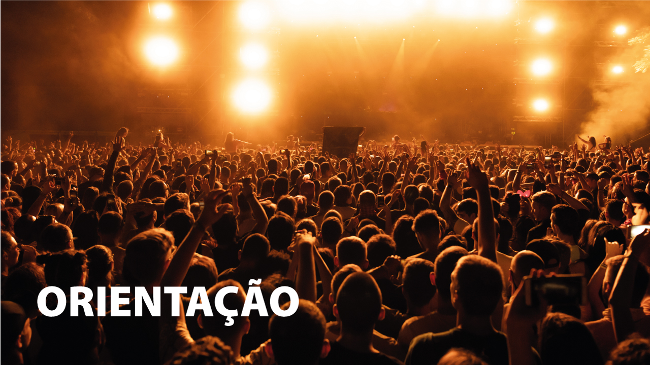 Banner horizontal com foto, em filtro laranja, de uma plateia que assiste a um show. Há várias pessoas, de costas para a foto. Algumas estão com braços levantados. No palco, à frente, há luzes amarelas que iluminam o público. No canto inferior esquerdo, o texto “Orientação”, em fonte branca. 