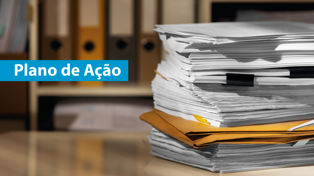 Pilha de papéis e pastas com a frase “Plano de Ação” em destaque sobre fundo de arquivos.