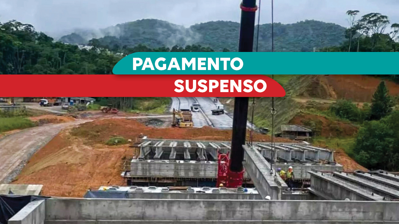 Imagem mostra obras em uma rodovia. Ao centro sobre tarjas verde e vermelha, está escrito “pagamento suspeito” 