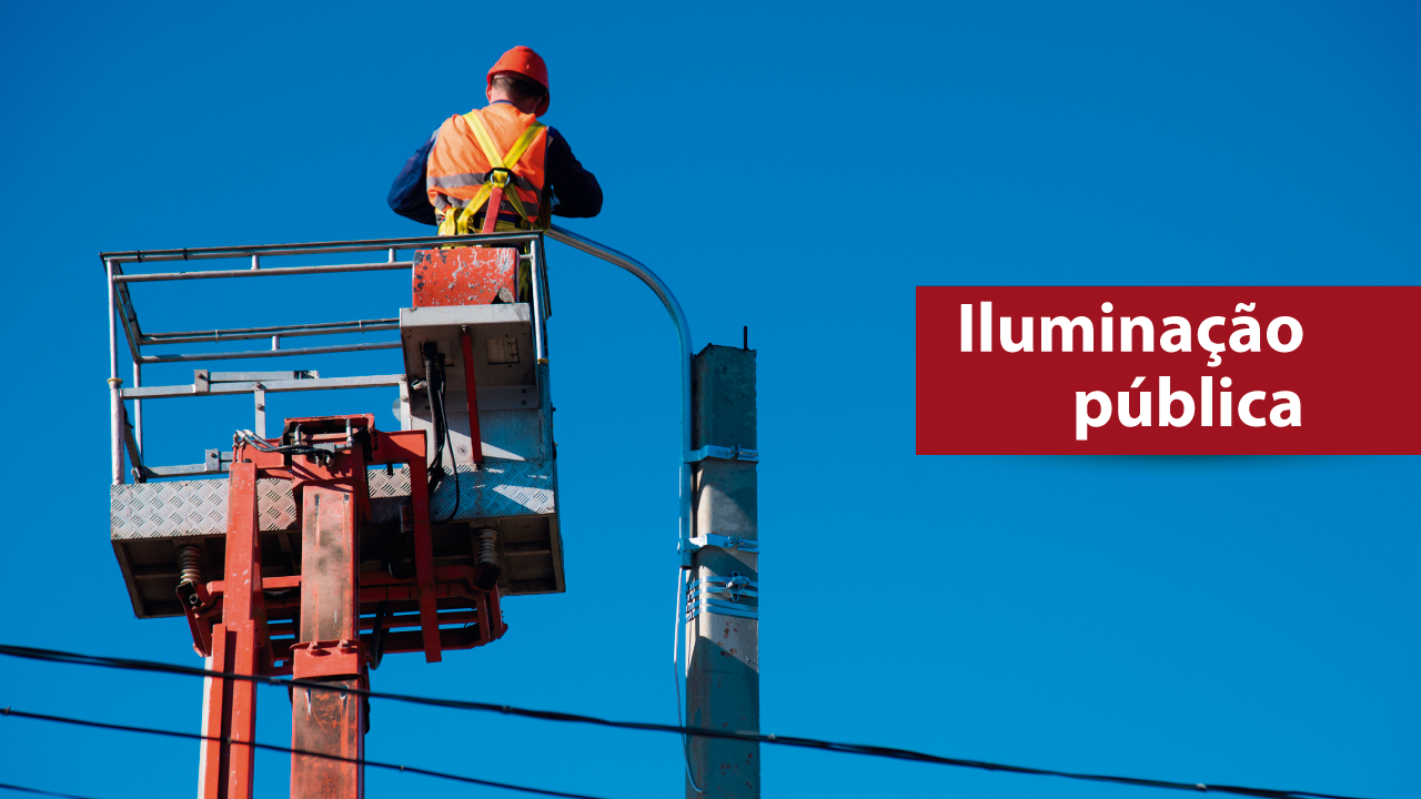 Imagem com fundo azul. Nela, há um homem que mexe em uma luminária de poste de rua. Ele está numa espécie de guindaste. À direita, sobre fundo vermelho, está escrito em branco "iluminação pública"