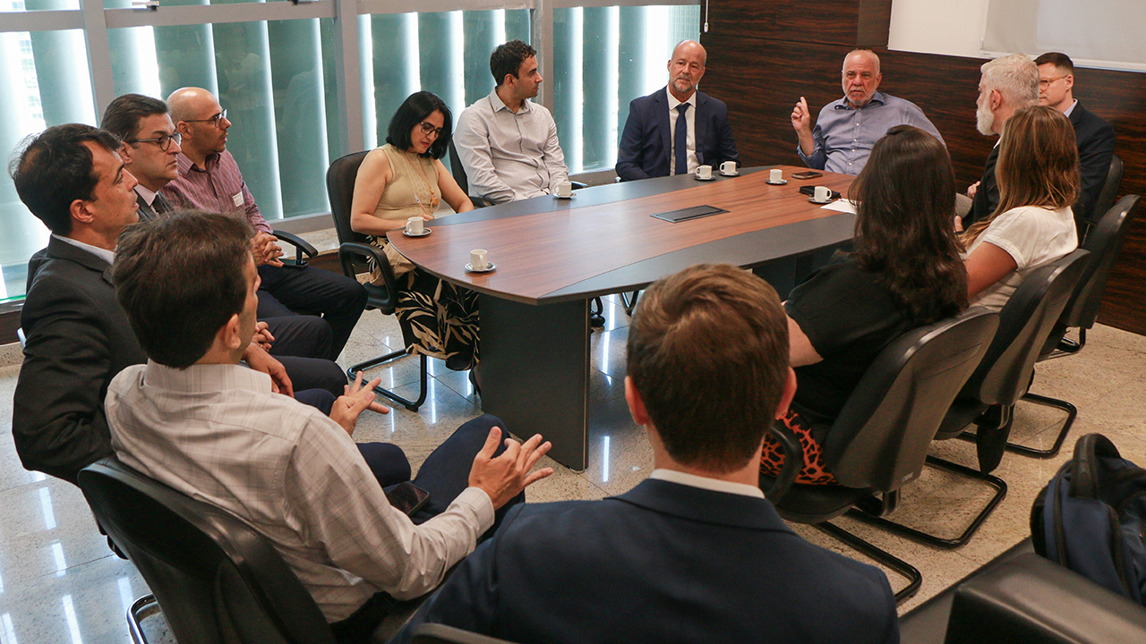 Foto da reunião realizada no gabinete do conselheiro Luiz Eduardo Cherem. Os participantes estão sentados ao redor de uma mesa. No total, são três mulheres e nove homens. Entre eles, o conselheiro Cherem e o secretário de Estado da Fazenda, Cleverson Siewert. 