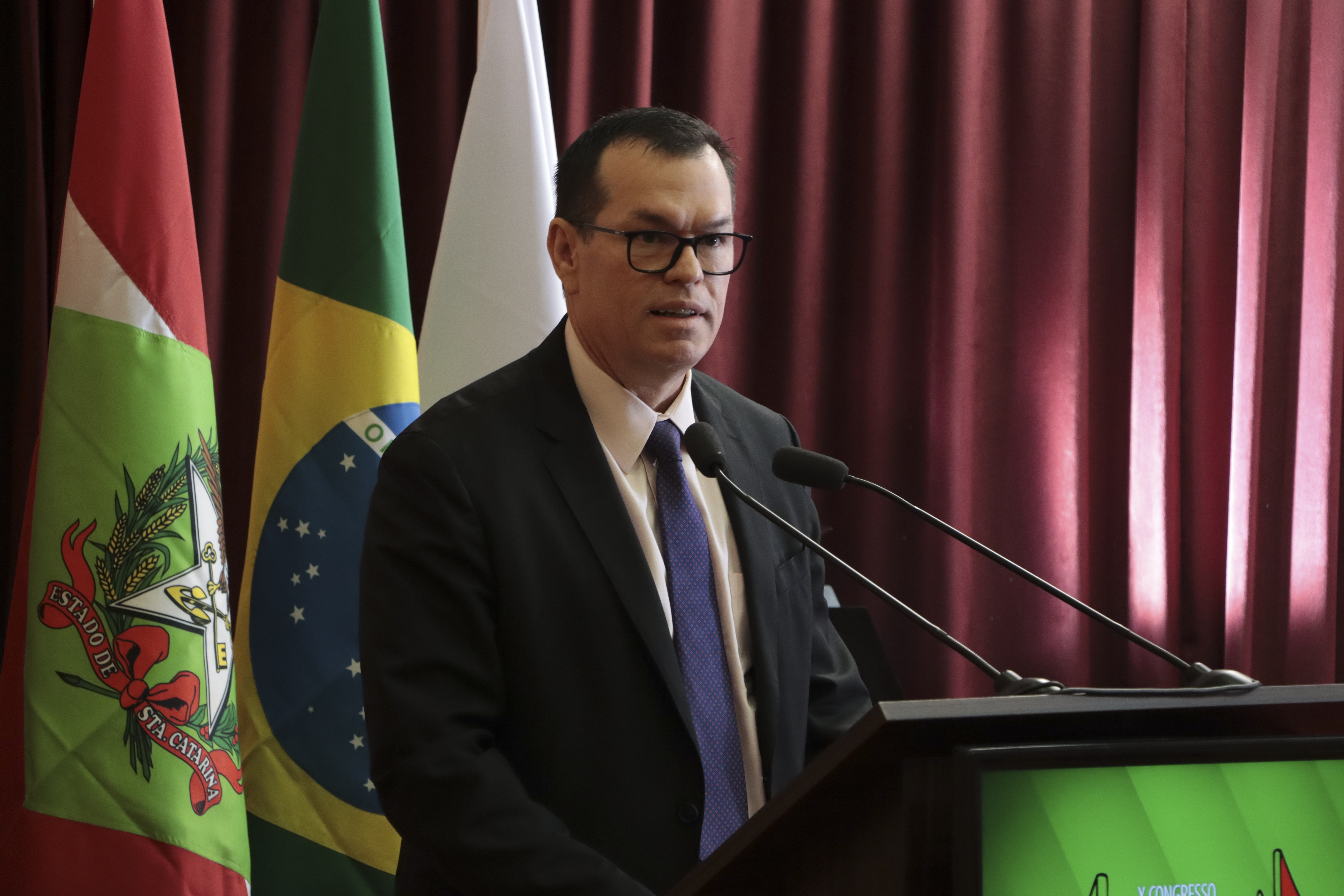 foto horizontal do conselheiro Adircelio de Moraes Ferreira Junior, no palco, em seu discurso de abertura da Mostra de Pesquisa da TCE/SC.