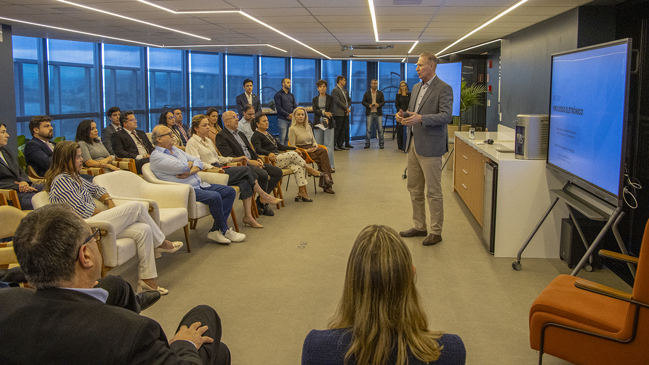 foto da apresentação dos novos módulos do processo eletrônico. O presidente do TCE/Sc, conselheiro Herneus De Nadal fala ao microfone para a plateia.