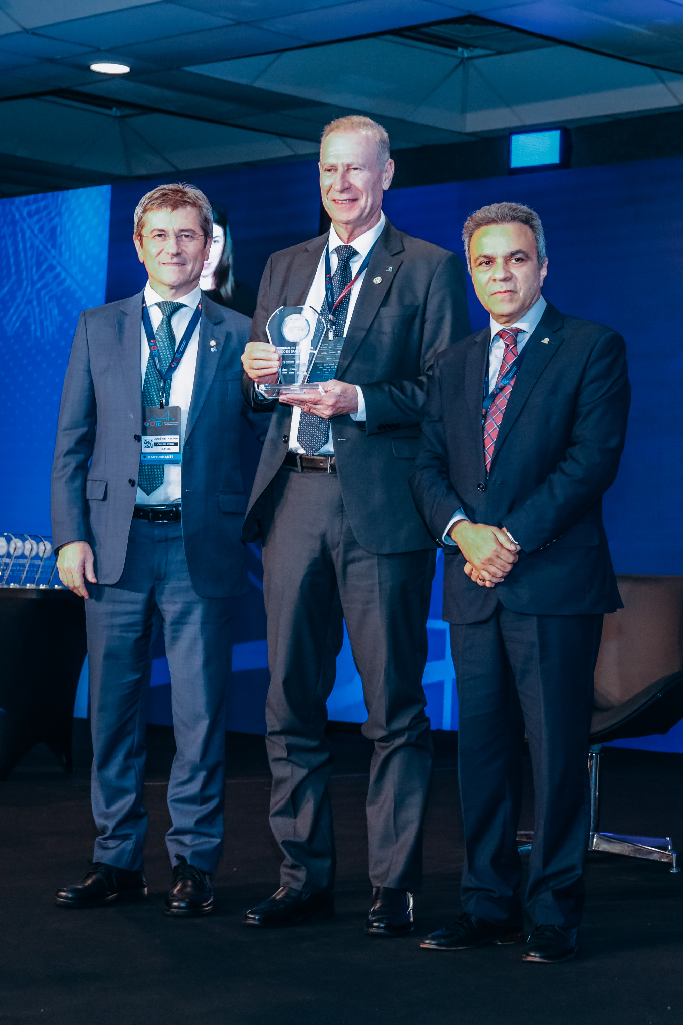 Foto vertical com os conselheiros José Nei Ascari, Herneus De Nadal (centro) e Edilson Silva.