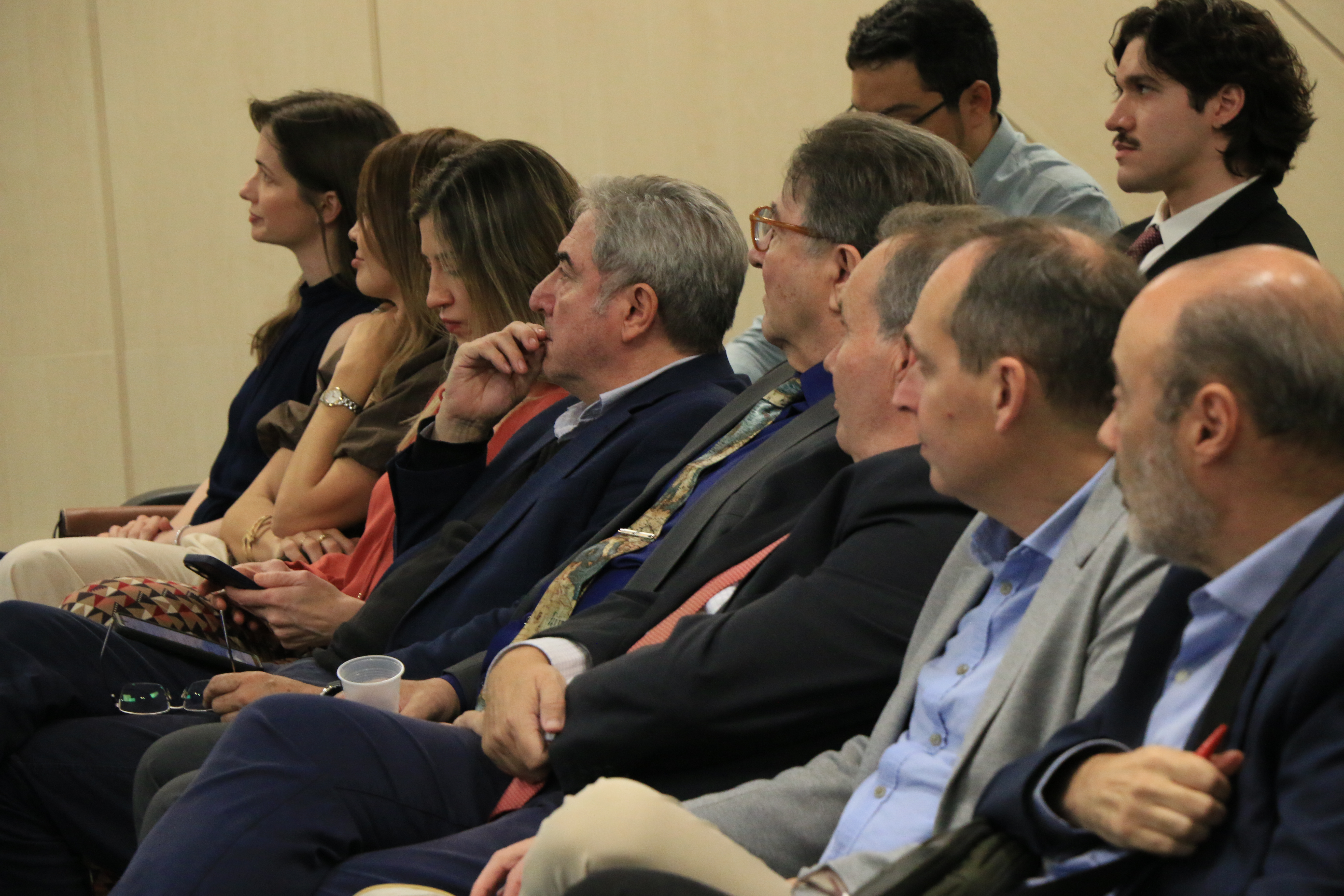Banner horizontal com foto de seis autoridades sentadas em poltronas lado a lado no palco do auditório do TCE/SC. Entre os presentes, o corregedor-geral, conselheiro Adircélio Ferreira Júnior, e o professor Luiz Henrique Cademartori. O cenário tem plantas decorativas. Ao fundo, projeção de slides.  Foto horizontal do conselheiro Adircélio Ferreira Júnior falando no púlpito do auditório. Ele é um homem branco, de cabelos escuros. Veste terno e gravata e usa óculos de grau. Ao fundo, no telão, projeção do logo do evento.  Foto horizontal do conselheiro substituto Gerson Sicca falando ao microfone durante evento. Ele é um homem branco, de cabelos claros. Veste terno e gravata e usa óculos de grau. Ao fundo, no telão, aparece imagem de exemplar da Constituição.  Foto horizontal do professor Luiz Henrique Cademartori falando ao microfone durante evento. É um homem branco, de cabelos grisalhos. Ao fundo, no telão, aparece exemplar da Constituição.  Foto horizontal do professor Roberto Pastor, da Universidade de Valência, falando ao microfone durante evento. É um homem branco, de cabelos claros. Gesticula enquanto fala.  Foto horizontal de parte da plateia. Há várias pessoas sentadas lado a lado acompanhando atentamente o evento.  