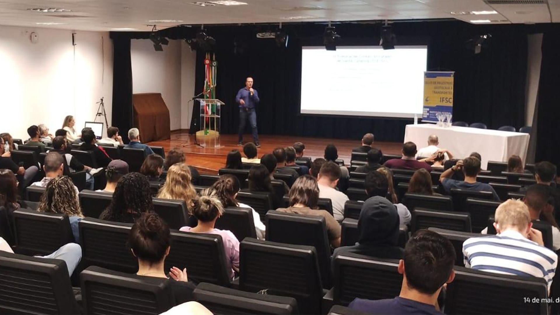 Foto de Rodrigo Glória ministrando palestra no auditório do IFSC