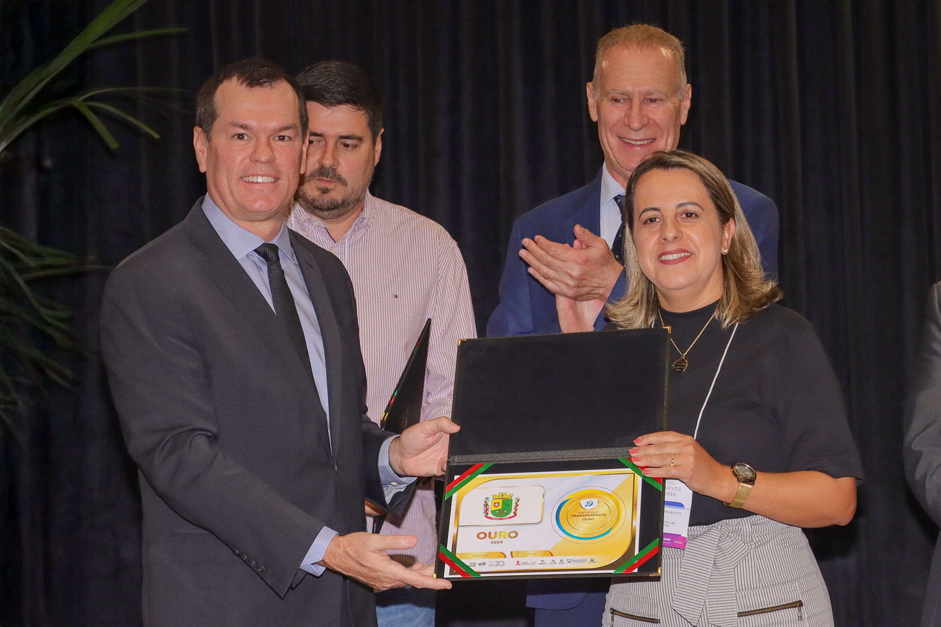 Foto horizontal com o conselheiro Adircélio de Moraes Ferreira Júnior e com a prefeita de Paulo Lopes, em primeiro plano. Ambos seguram o certificado.