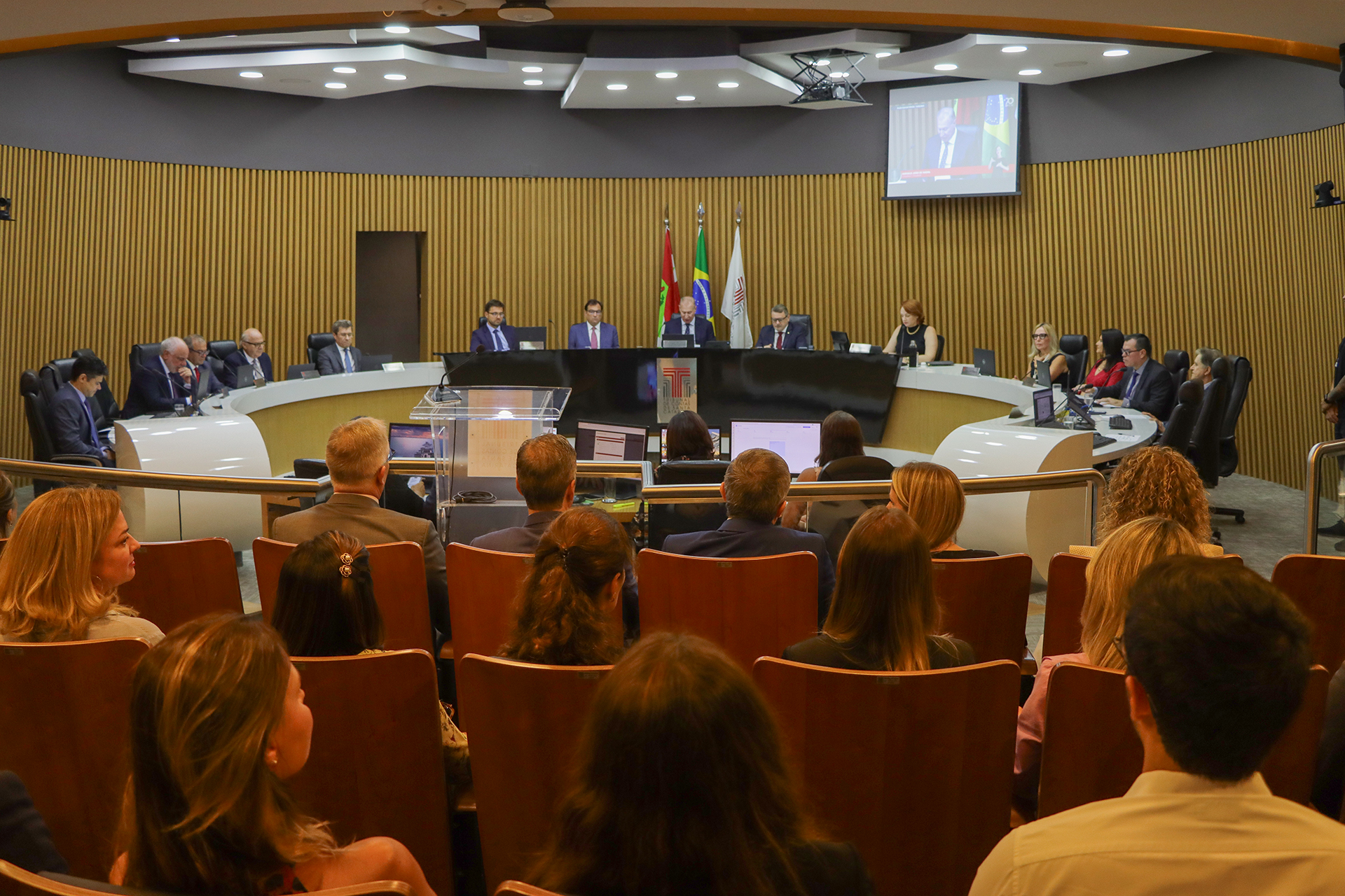 Foto da sessão especial, com a plateia em primeiro plano e os conselheiros e os homenageados ao fundo.