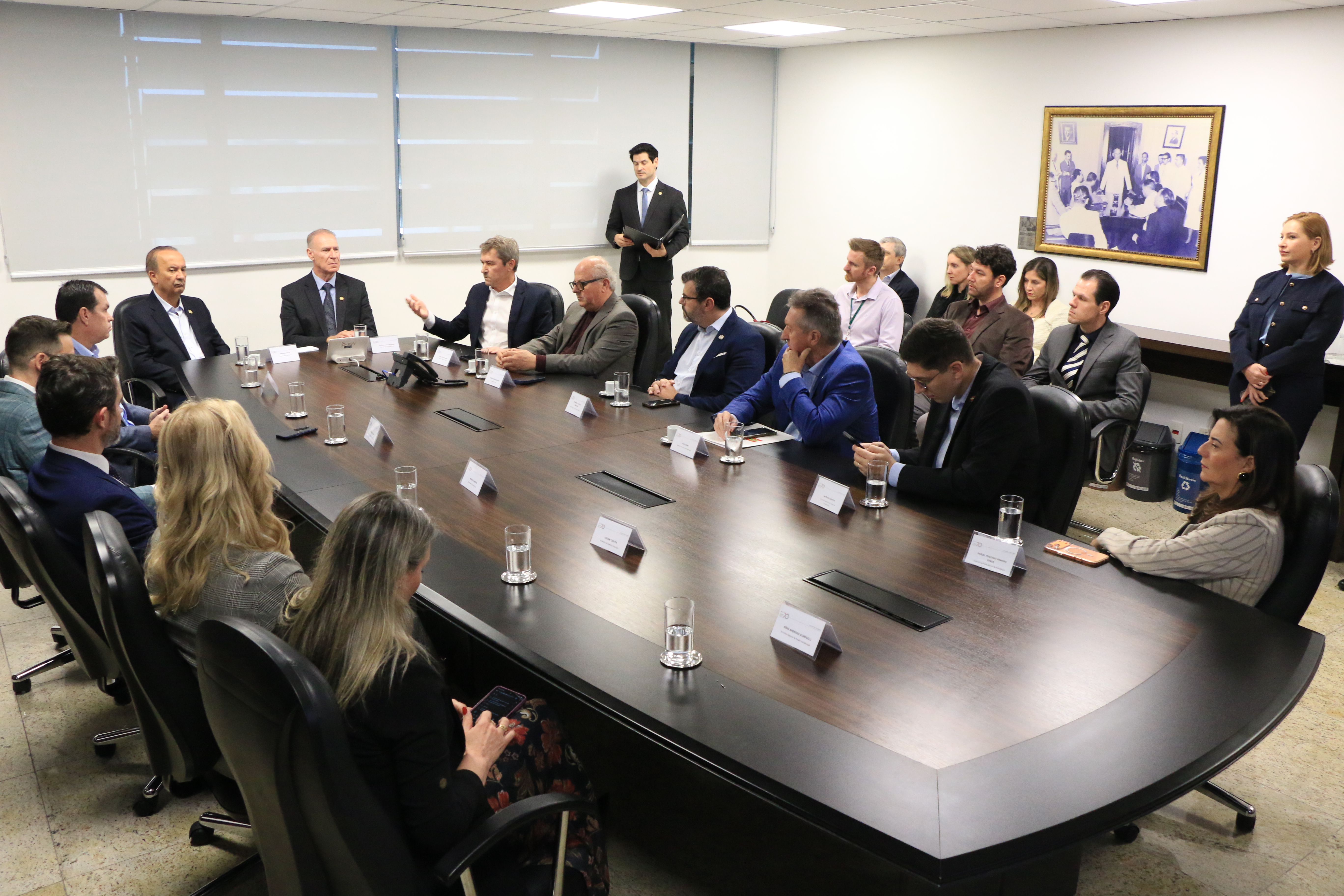 Foto horizontal que mostra vários participantes sentados diante de uma mesa enquanto conversam em reunião. Entre os presentes, o presidente Herneus e o governador Jorginho Mello, os conselheiros Wilson Wan-Dall, Adircélio Ferreira Júnior e José Nei Ascari, integrantes do TCE/SC e do governo do Estado. 