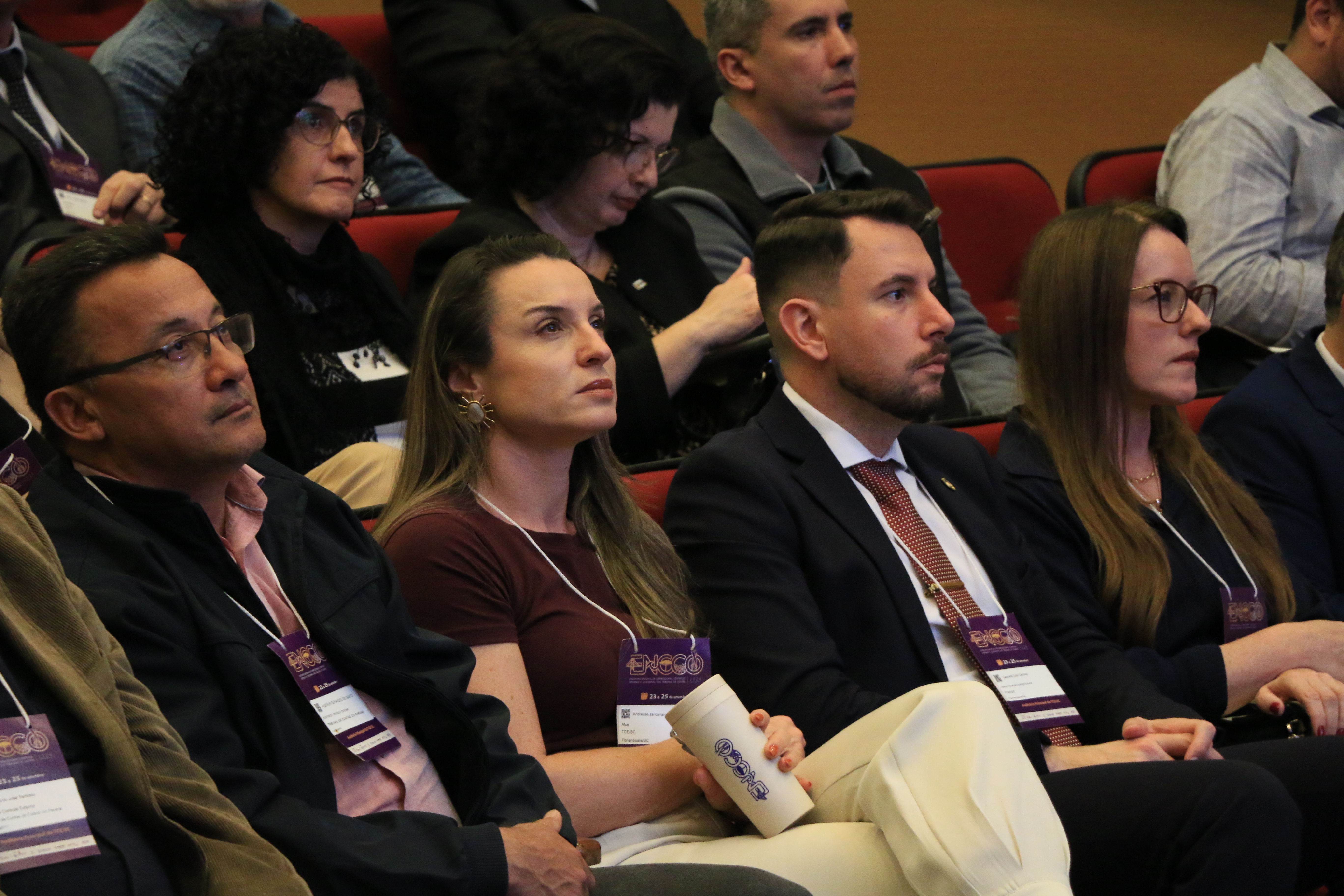 Foto horizontal de parte da plateia acompanhando as palestras. Há várias pessoas sentadas lado a lado no auditório do Tribunal.
