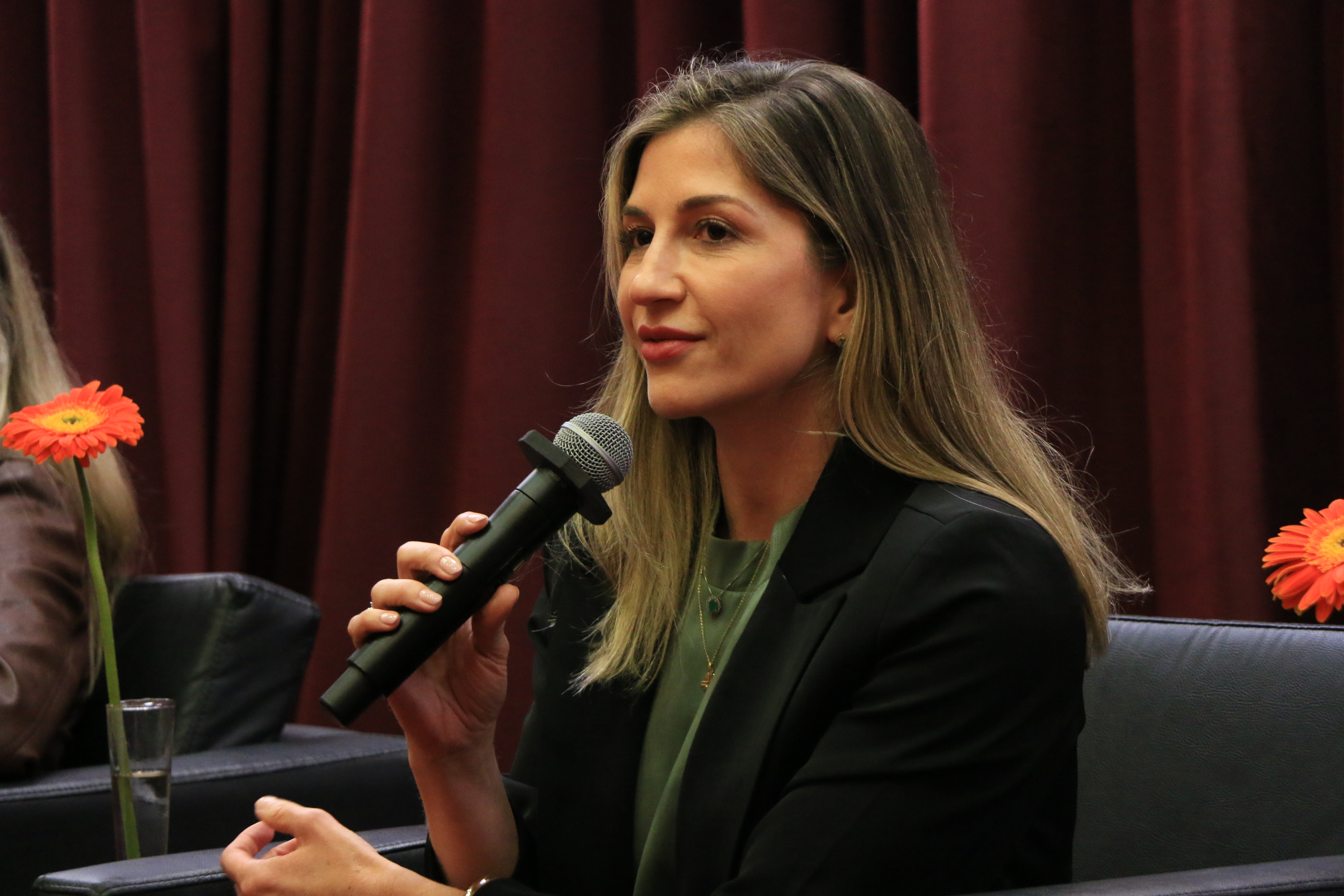 ​​Foto da diretora executiva do Icon, Marina de Miranda, falando ao microfone durante o evento. Ela é uma mulher branca, de cabelos claros. Está sentada em poltrona, no palco. 