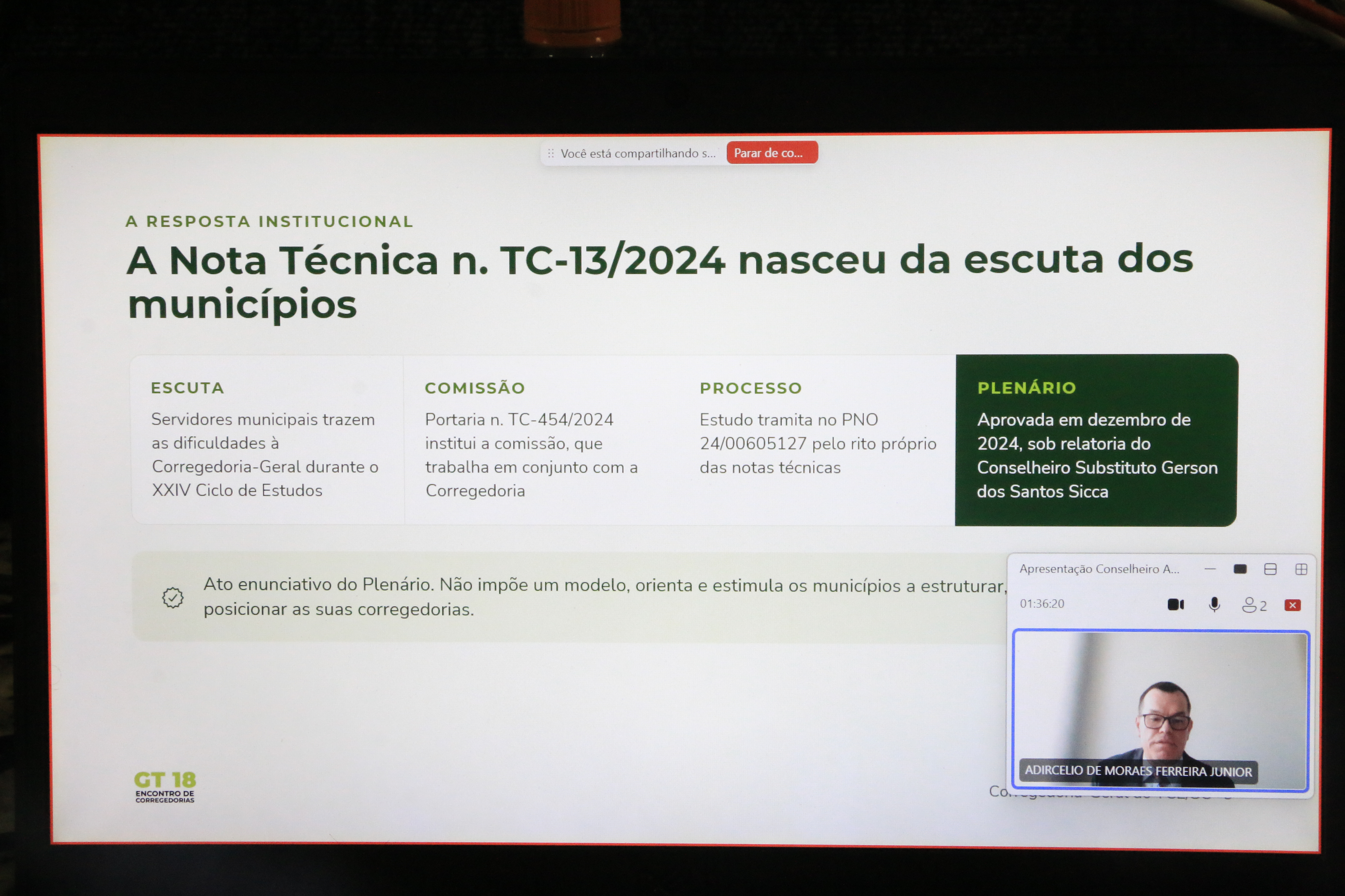 Imagem da palestra sendo exibida no telão, com os slides ao centro, em destaque, e a imagem do conselheiro Adircélio no canto inferior direito.
