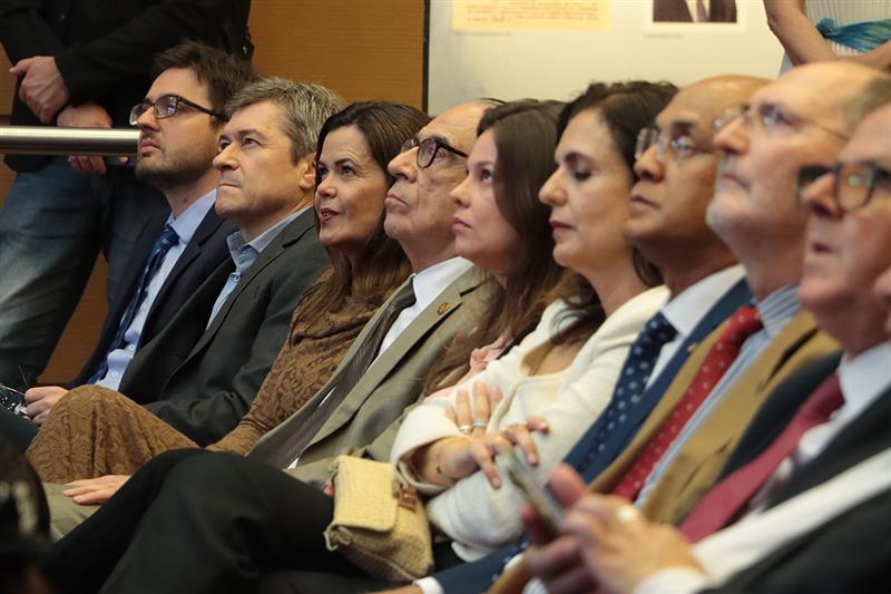 Foto de conselheiros do TCE/SC e membros da comitiva espanhola em meio à plateia, durante o evento. Entre os presentes, os conselheiros José Nei Ascari, Sabrina Nunes Iocken e Wilson Wan-Dall e a procuradora-geral do MPTC/SC, Cibelly Farias.