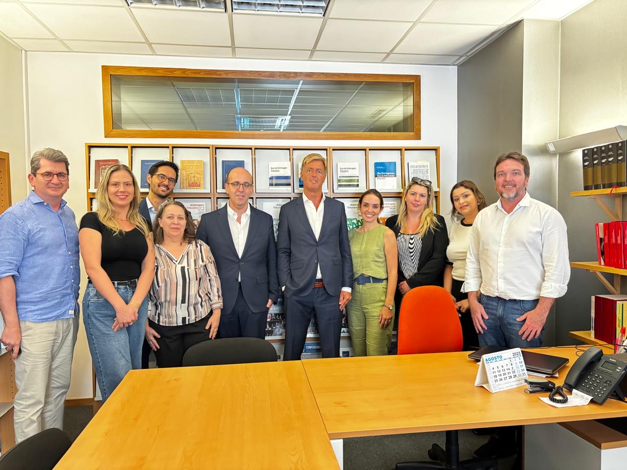 Foto com os auditores fiscais de Controle Externo Juliano Frasseto Velho, Renato Bossle Miguel e Rafael Scherb, na Câmara de Arbitragem Administrativa (CAAD), e outras pessoas. Ao centro, o árbitro Francisco José Nicolau Domingos e Nuno Villa-Lobos, presidente da CAAD. Na lateral direita, o professor André Lupi. 