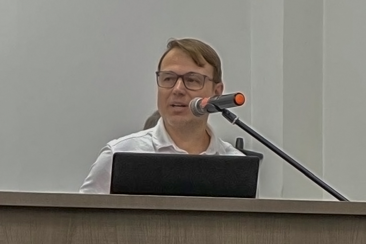 Foto do servidor do TCE/SC Luiz Alexandre Steinbach falando ao público. Ele é um homem branco, veste camisa branca e usa óculos.