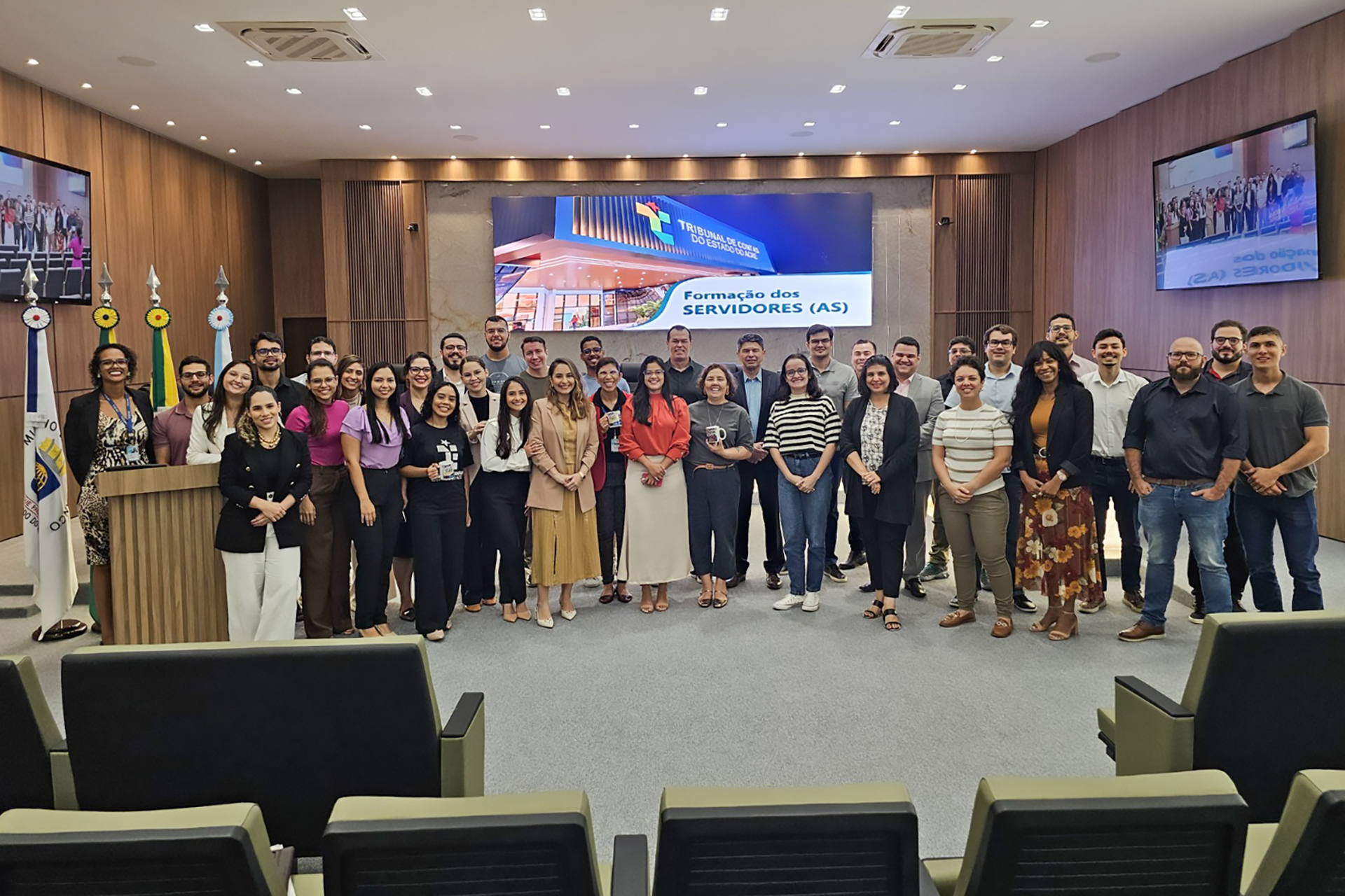 Foto horizontal que mostra várias pessoas em pé, uma ao lado da outra, posando para a foto, no plenário do TCE/AC. Entre os presentes, os novos servidores e o conselheiro do TCE/SC Adircélio de Moraes Ferreira Júnior. 