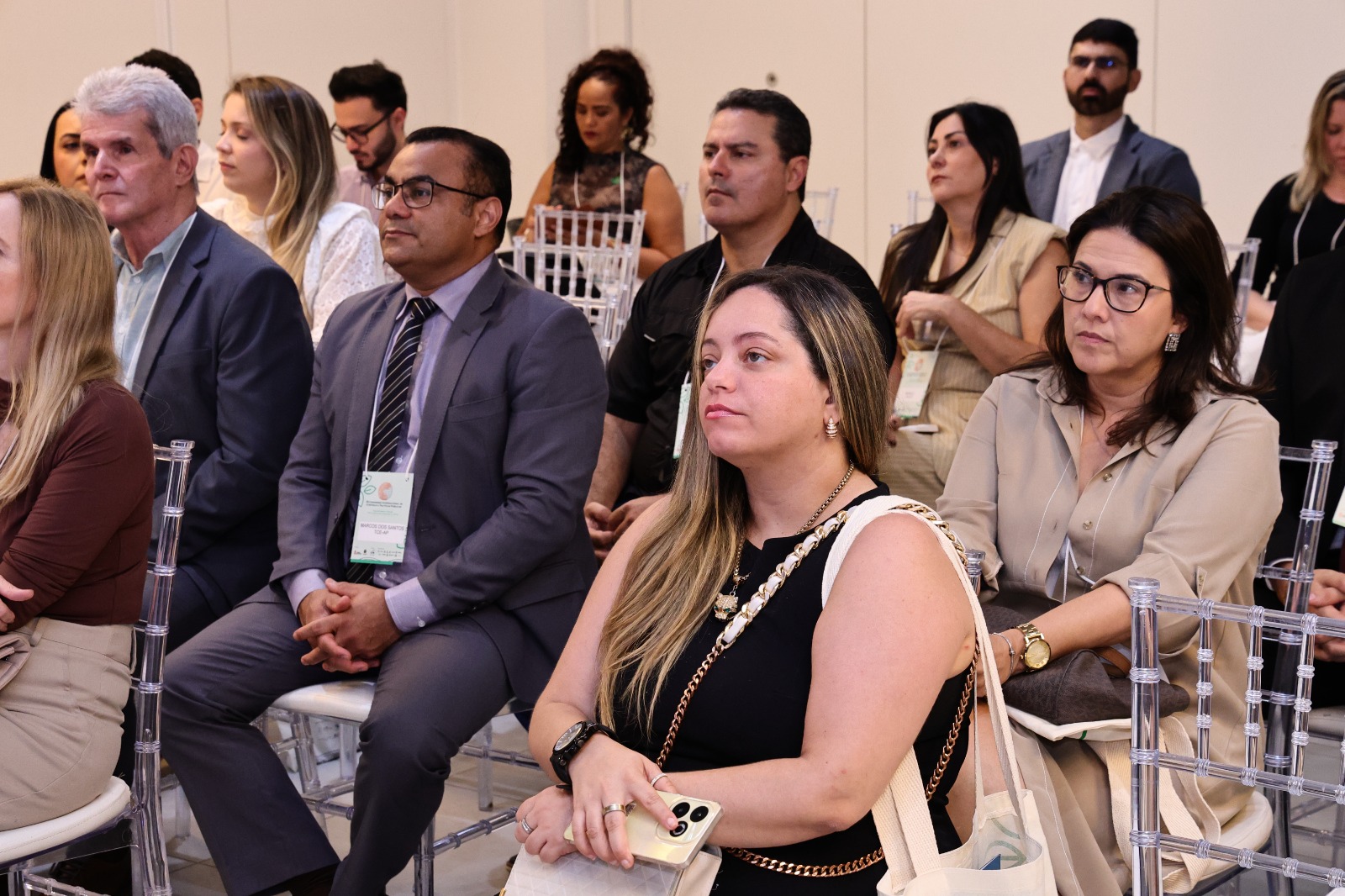 Banner horizontal do público participante do nono Congresso Internacional de Controle e Políticas Públicas. Há várias pessoas, sentadas em cadeiras em uma sala. Entre elas, a diretora Michelle Al Ackar.