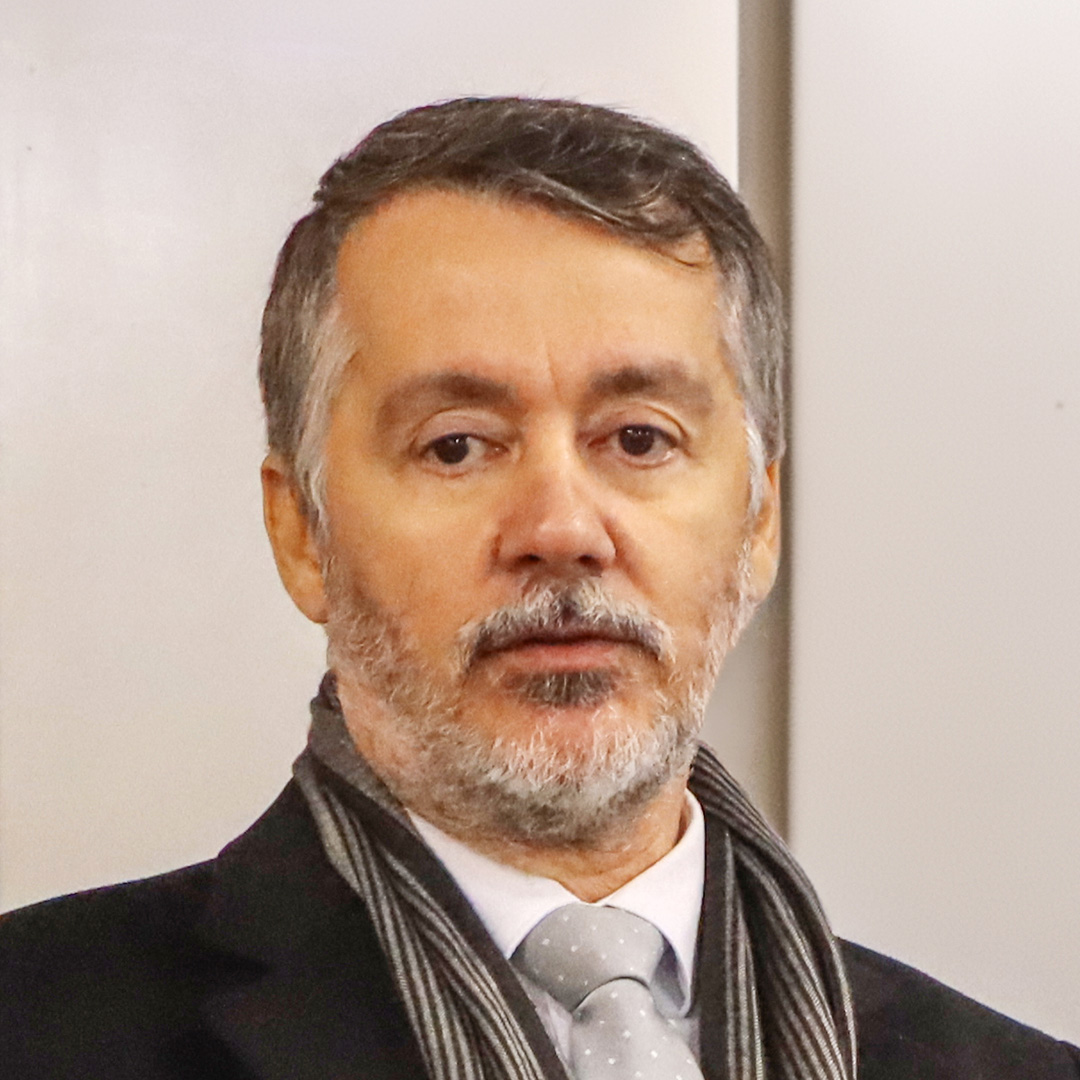 Foto de Rogério Guilherme de Oliveira, coordenador do Coral do TCE/Sc. Ele é um homem branco, com cabelos e barba grisalhos.