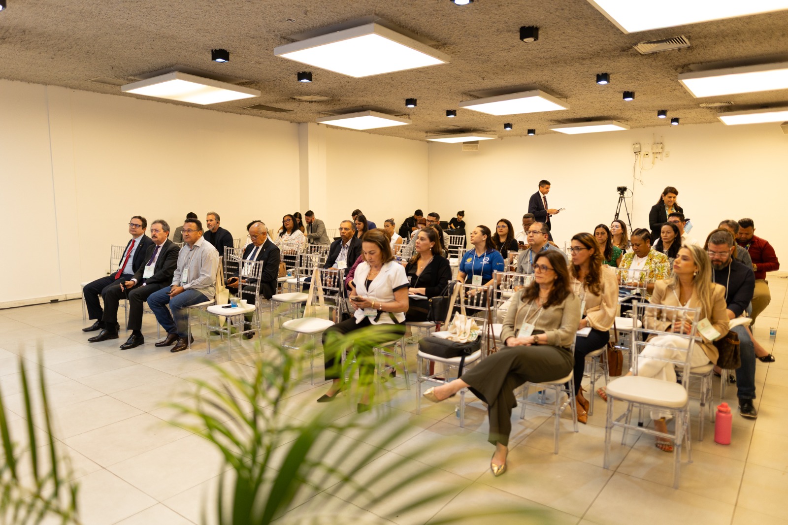 Foto recortada de parte da plateia presente durante o evento. Em meio há várias pessoas, está a diretora Walkiria.