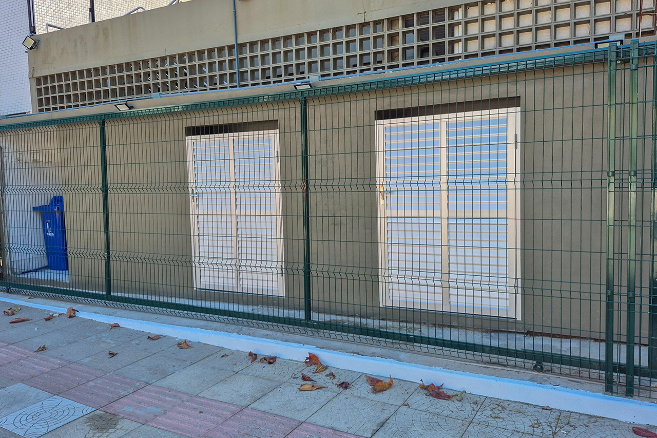 Foto horizontal da central de resíduos após o PGRS. Há uma edícula construída com duas portas de alumínio, na parte externa do TCE.