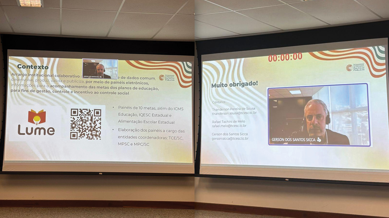 Imagem horizontal de dois grandes telões, lado a lado, exibindo a apresentação de slides sobre o Acordo Lume do conselheiro substituto Gerson Sicca, que aparece na tela, participando remotamente.