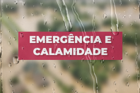 Imagem mostra gotas de água que remetem à chuva. Ao centro, em letras brancas sobre fundo vermelho, a expressão “emergência e calamidade”