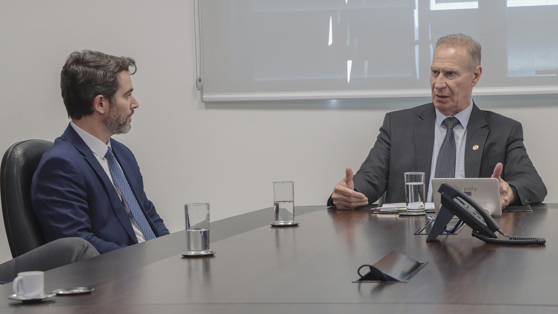 Banner horizontal com foto de reunião institucional. Aparecem, lado a lado, o presidente do TCE/SC, conselheiro Herneus De Nadal, e o procurador-geral do Estado, Marcelo Mendes. Herneus gesticula enquanto fala. Sobre a mesa, há copos de água. 